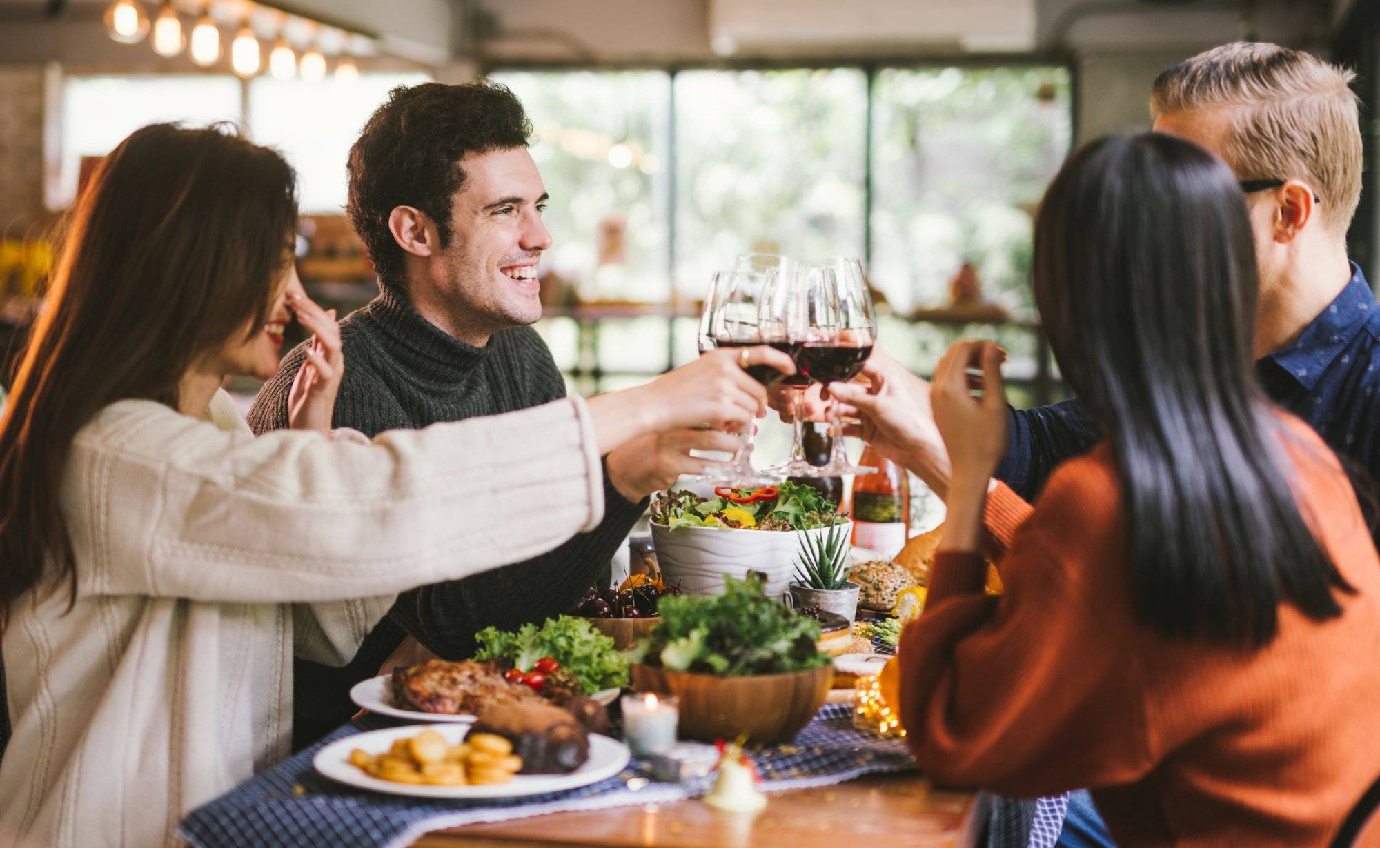 Dinner with friends. Group of young people enjoying dinner together. Dining Wine Cheers Party thanksgiving Concept Dinner with friends. Group of young people enjoying dinner together. Dining Wine Cheers Party thanksgiving Concept