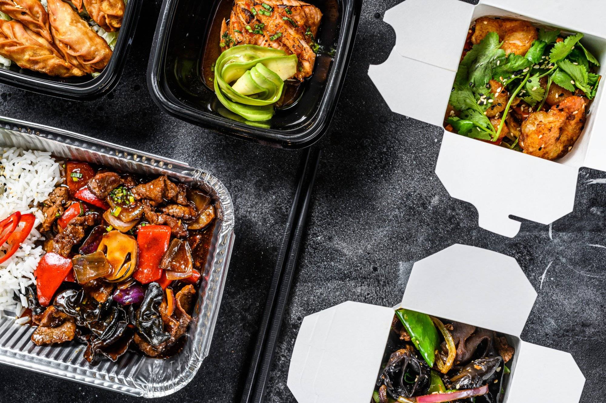 Spring rolls, dumplings, gyoza and wok noodles in Take away box. Healthy lunch. Take and go organic food. White background. Top view Spring rolls, dumplings, gyoza and wok noodles in Take away box. Healthy lunch. Take and go organic food. White background. Top view