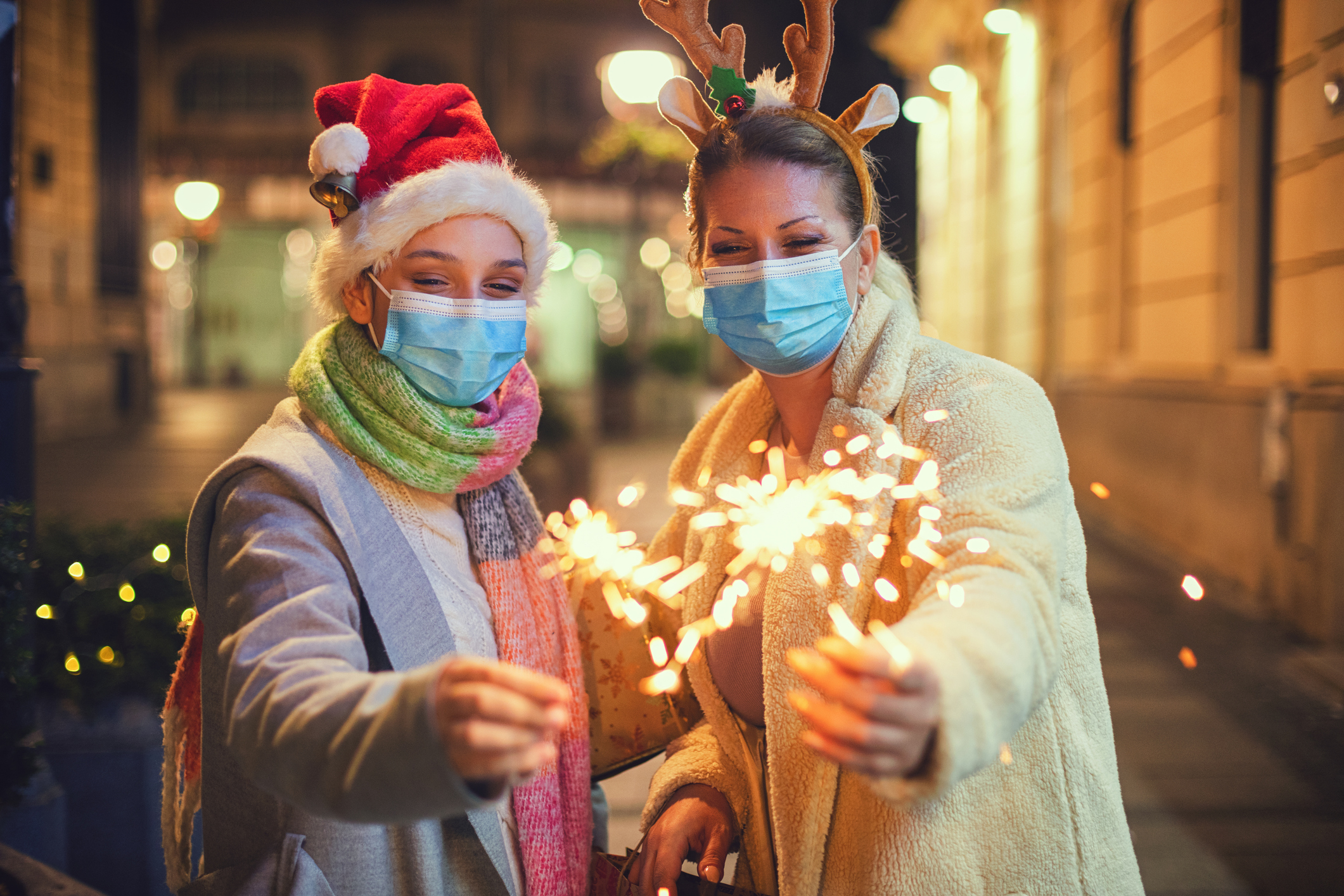 Family having fun while celebrating Christmas during COVID-19 pandemic. They wears a protective mask to protect from coronavirus COVID-19.
