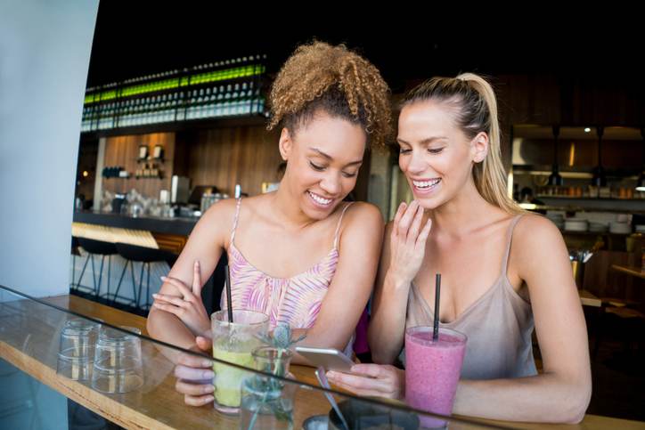 Women friends social networking at a cafe