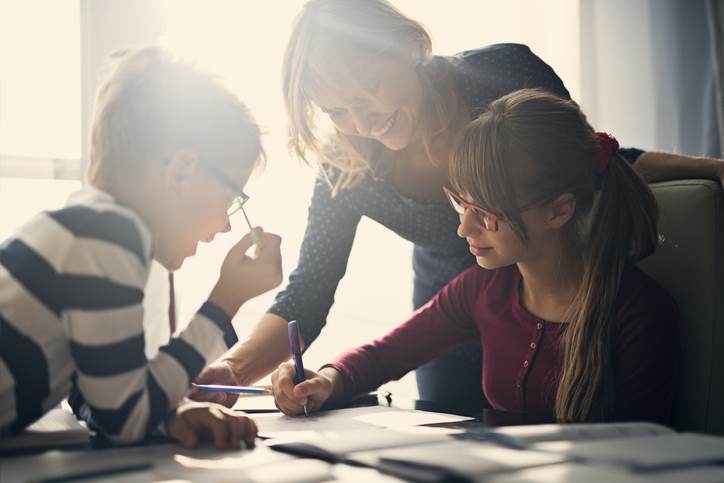 Mother halping kids to do homework Mother halping kids to do homework