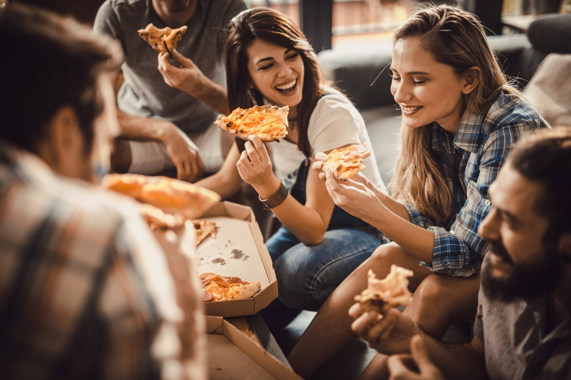 Young happy friends having fun while eating pizza at home. Young happy friends having fun while eating pizza at home.