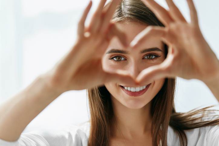 Beautiful Happy Woman Showing Love Sign Near Eyes. Beautiful Happy Woman Showing Love Sign Near Eyes.