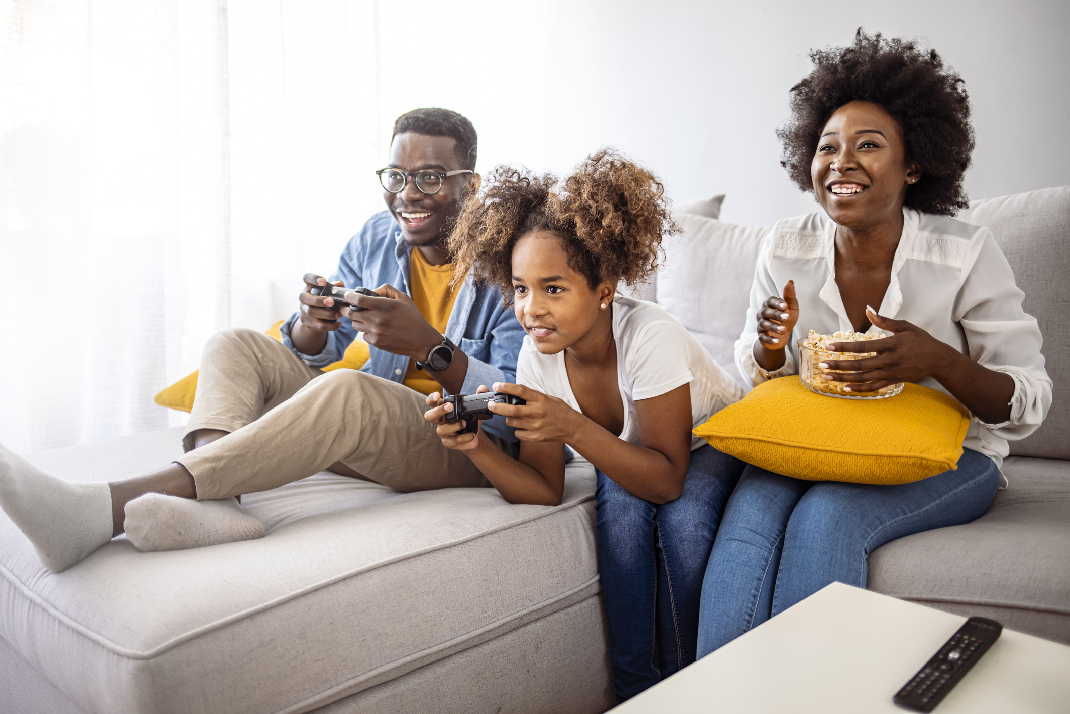 Smiling family sitting on the couch together playing video games